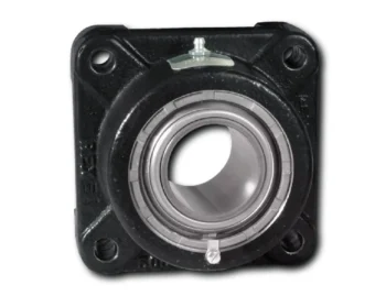 Close-up of a black bearing housing showing a circular silver inner bearing race and two mounting holes, with a small metal adjustment lever on top.