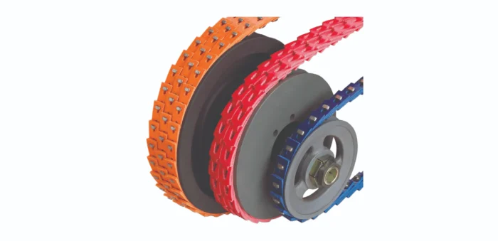 Assorted abrasive sanding belts in orange, red, and blue mounted on a gray spool. (Industrial grinding belts)