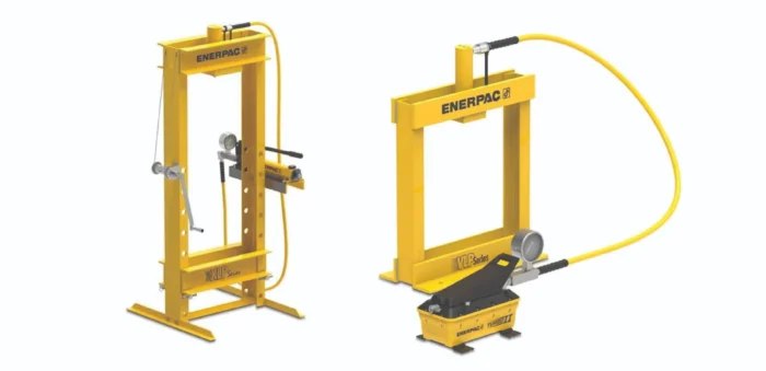 Two yellow Enerpac hydraulic press machines with hoses and controls on a white background (industrial workshop setup).